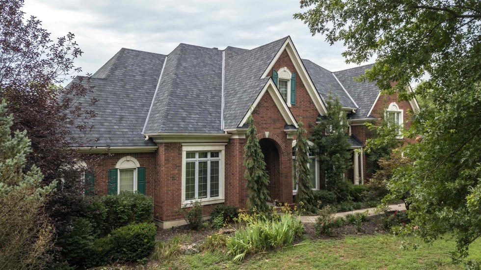 residential property featuring a brick facade and a landscaped front yard
